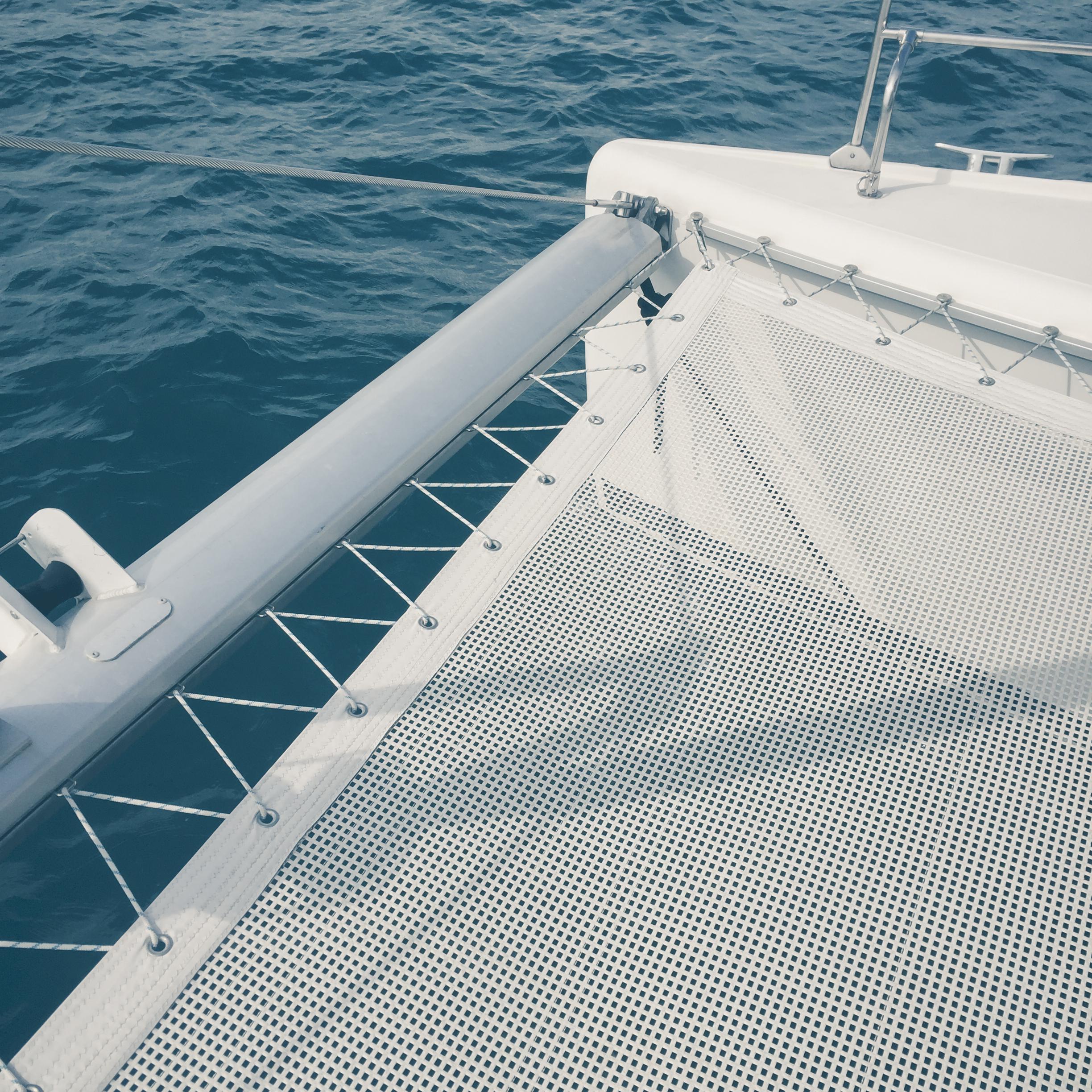 Catamaran deck and netting above open water