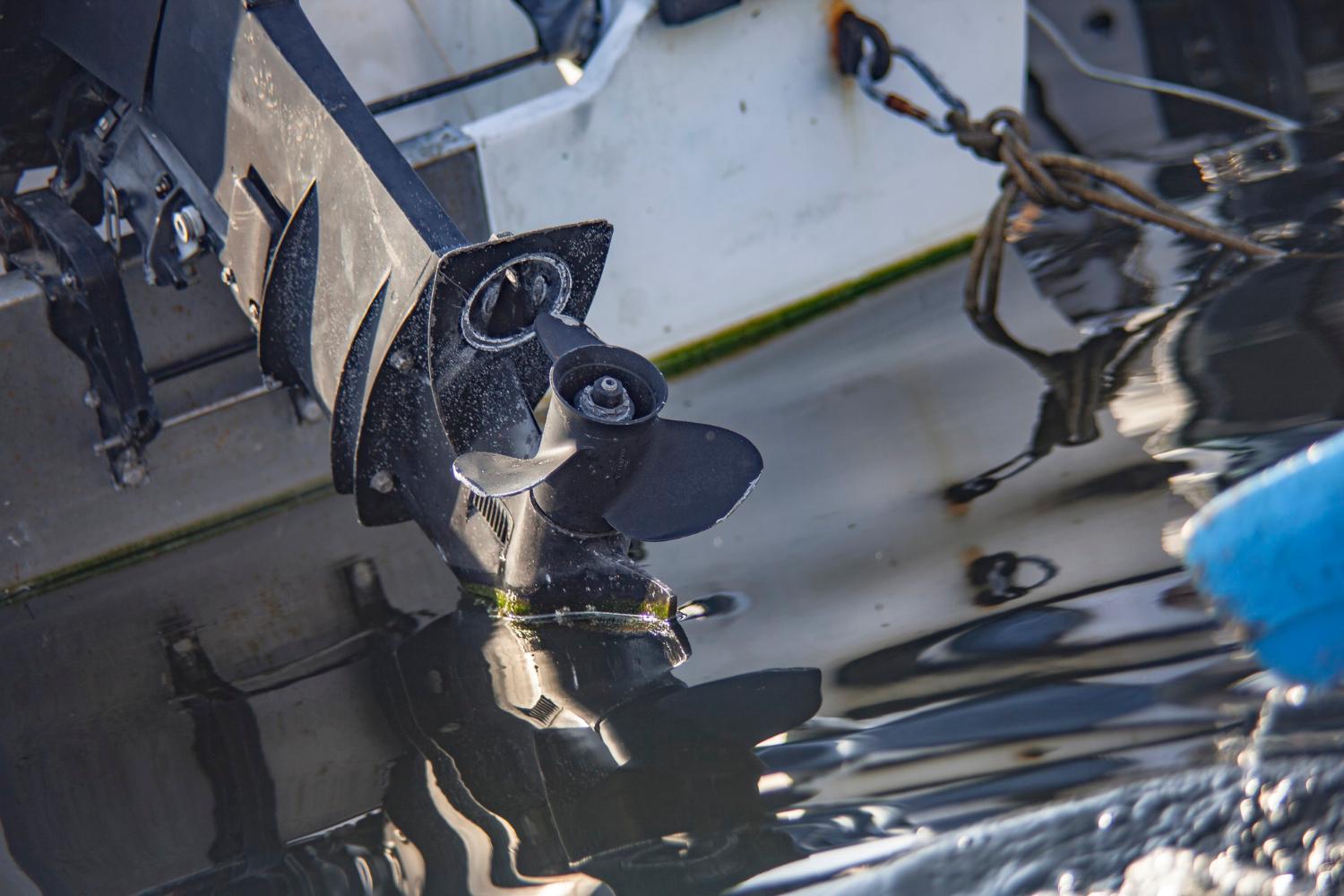 Close-up of a marine propeller partially submerged beside a hull
